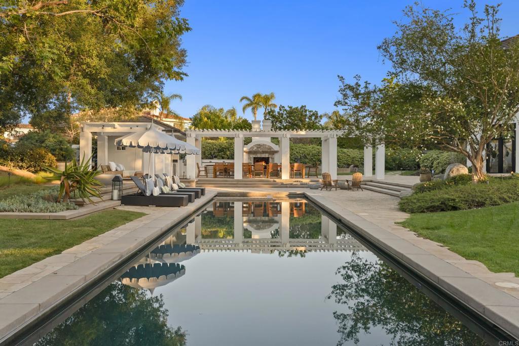 Pergola dining area for 25 reflected in the 70-foot lap pool.