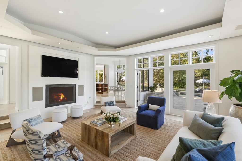 Family room with linear fireplace and French doors opening to the pool terrace.