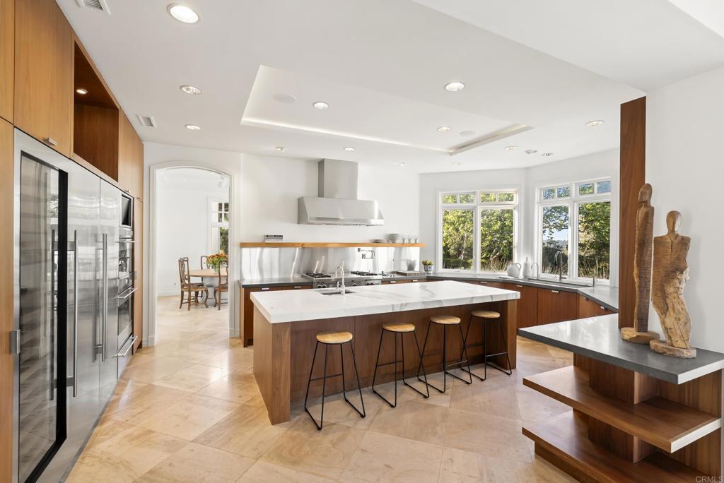Chef's kitchen with Carrara marble counters, custom walnut cabinetry, and Sub-Zero appliances.
