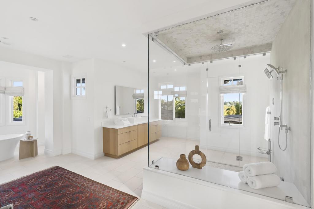 Primary spa bath with freestanding soaking tub and walk-in marble shower.